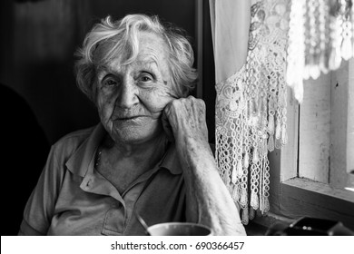 Black-and-white portrait of an elderly woman in her home. 