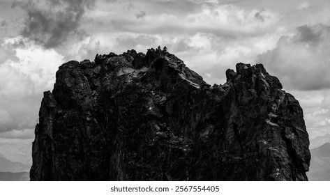 Black-and-white view of climbers atop a rugged summit in the French Alps. - Powered by Shutterstock