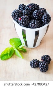 Blackberries in a small cap. Selective focus. Vertical view.