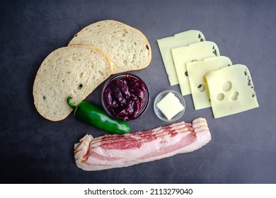 Blackberry Bacon Grilled Cheese Sandwich Ingredients: Overhead View Of Sourdough Bread, Raw Bacon, And Other Ingredients On A Dark Background