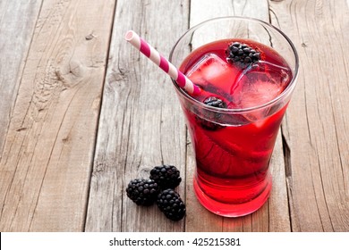 Blackberry Fruit Drink In A Glass With Straw Over A Rustic Wooden Background