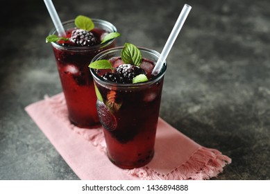 Blackberry mojito with mint, ice and frozen berries.
