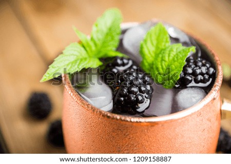 Blackberry moscow mule in copper mug on the rustic background. Selective focus. Shallow depth of field.