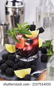 Blackberry summer mojito cocktail. Cold refreshing organic alcoholic drink with berries, lime, mint