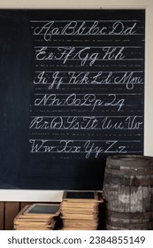 Blackboard with cursive writing and stack of slates