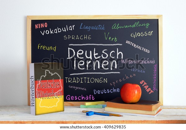 Blackboard in a German\
language classroom with the message LEARN GERMAN and some other\
linguistic words.