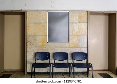 Blackboard On A Old Hospital Wall Surrounding By Doors A Chairs