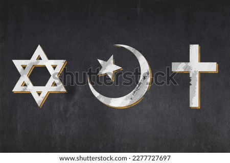 Blackboard with the symbols of the three Abrahamic religions: the Jewish Star of David, the Christian cross, and the Islamic star and crescent drawn in the middle.