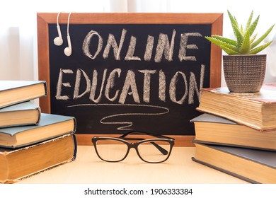 Blackboard with text online learning, stack of books glasses. Distance education concept.