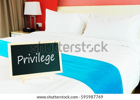 Blackboard with text privilege on empty bed.