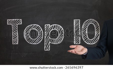 Blackboard with the text TOP 10  presenting on blackboard by hand