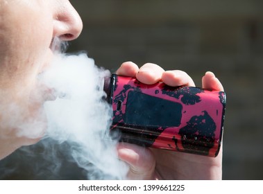 Blackburn, Lancashire/UK - May 16th 2019: Close Up Of Middle Age Blonde Hair Caucasian Woman Smoking An Electronic Cigarette Outdoors