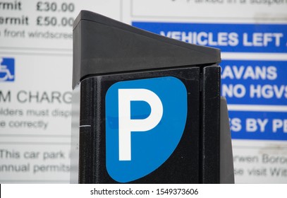 Blackburn, Lancashire/UK - November 3rd 2019: Close up of black parking meter with Parking sign and blurred tariff board in the background