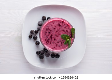 Blackcurrant Smoothie In A Glass Cup On A White Background, Top View