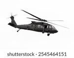 Blackhawk helicopter operated the United States Army. Government aircraft in all black flying by isolated on white background. Military airborne transport flown by National Guard