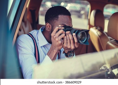 A blackman shooting on dslr from the car. - Powered by Shutterstock