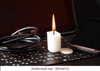 Blackout Concept. Lighting Candle On Laptop Near Cable