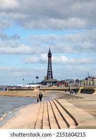 Blackpool, Lancashire, United Kingdom - 5 March 2022: Scenic View Of Blackpool From The South With Waves Breaking On The Steps, People On The Promenade And The Golden Mile And Tower In The Distance