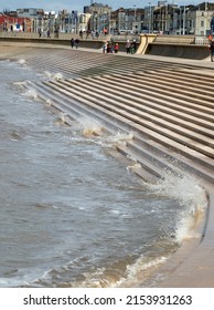 Blackpool, Lancashire, United Kingdom - 5 March 2022: Scenic View Of Blackpool From The South With Waves Breaking On The Steps, People On The Promenade And Seafront Buildings