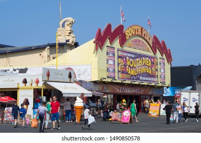 Blackpool, Lancashire/UK - August 27th 2019: The South Pier At Blackpool, Holiday Makers Walking Along The Promenade On A Warm Sunny Summer Day