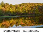 Blacksburg, Virginia, USA: Reflection of forest beside the pond under blue sky at Glen Alton Recreation Area in autumn. Autumn scenery.