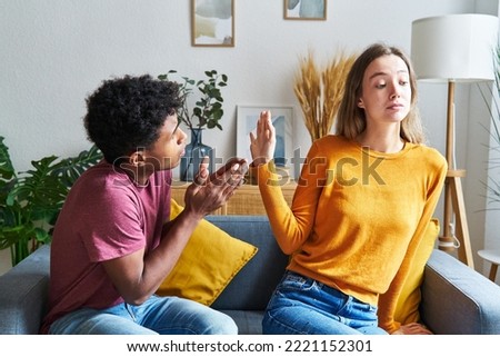Black-skinned man begging for forgiveness and Caucasian woman turning him down in a house Foto stock © 
