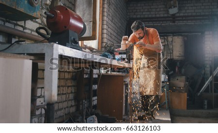 Blacksmith checks the thickness of the sharpening