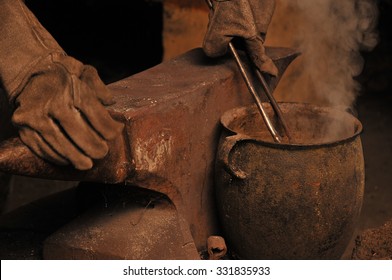 A blacksmith cooling a horseshoe in a pot - Powered by Shutterstock