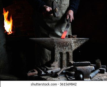 The blacksmith forge the hot metal on the anvil in smithy