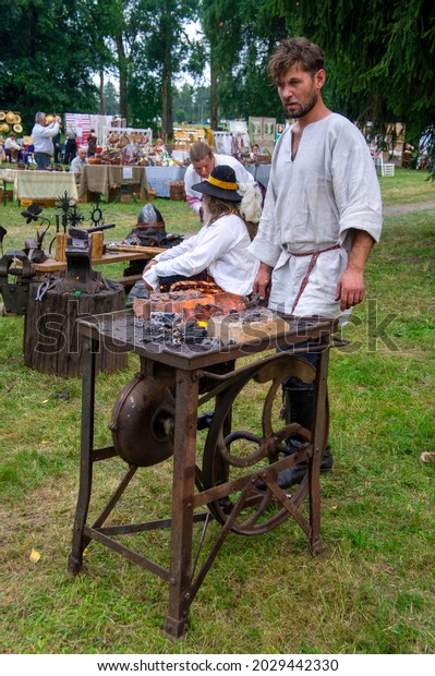 Blacksmith forges iron with a forge at a\
medieval festival. 20 August 2021, Nesvizh,\
Belarus