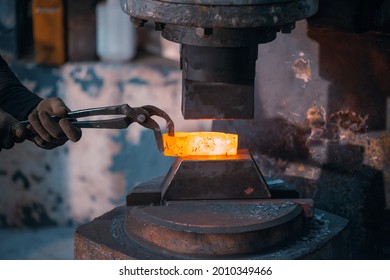 Blacksmith forges from a piece of metal on a blacksmith's hammer, a percussion machine.
