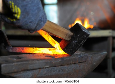 Blacksmith forges a red-hot iron in the forge - Powered by Shutterstock