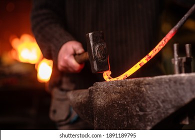 A Blacksmith Forging A Curl From A Red-hot Flattened Billet With A Hammer. Handmade In The Forge Concept