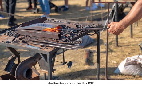 Blacksmith furnace with burning coals, tools, and glowing hot metal workpieces. Production metal products manually. Details handmade of metal. - Powered by Shutterstock