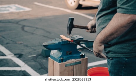 Blacksmith hammering metal on an anvil - Powered by Shutterstock