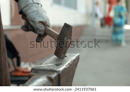 Blacksmith hits anvil. Hammer and anvil. Metal Processing Details. Rameslennik works.