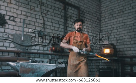 Blacksmith inspects the workpiece knife