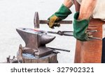 Blacksmith making a decorative element on the anvil
