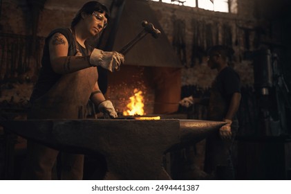 Blacksmith, metal and hammer in workshop for craft, skill and artisanal creativity. Woman, manufacturing and hot iron in foundry for production, forging and shaping with safety gear in steel industry - Powered by Shutterstock