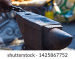 blacksmith performs the forging of hot glowing metal on the anvil