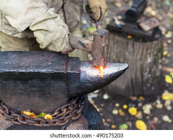 Blacksmith Processing Red Hot Iron Rod On Anvil In Outdoor Rural Smithy