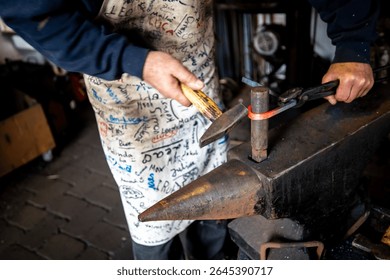 Blacksmith shaping glowing metal on an anvil, skillfully using a hammer and tongs in a traditional workshop, exemplifying the artistry and labor involved in metalworking