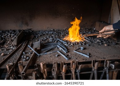 Blacksmith skillfully using metal pliers to grip a glowing piece of iron over burning coal in a traditional forge, surrounded by various tools hanging within the workshop