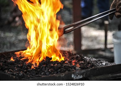 Blacksmith Stoking With Tongs In Fire & Coals