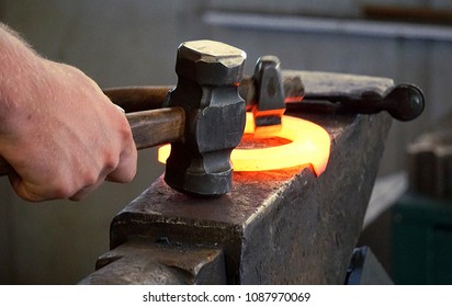Blacksmith Strikes While Iron is Hot Making Horseshoe on an Anvil