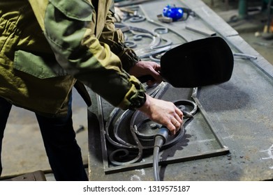 Blacksmith in work clothes is in the forge