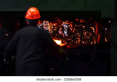 Blacksmith Work With Red Hot Iron Under A Press On Metallurgical Plant. Metal Forging, Stamping Under Hammer Forge At Workshop Of Forge Factory. Blacksmithing, Steelmaking And Hot Rolling Mill.