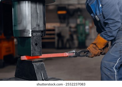 Blacksmith Worker uses hydraulic hammer to make repair part for an industrial machine. - Powered by Shutterstock