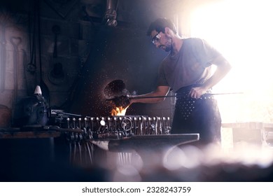 Blacksmith working at fire in forge - Powered by Shutterstock