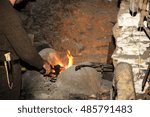 Blacksmith working in the forge processes the metal . The photograph on the subject of blacksmithing